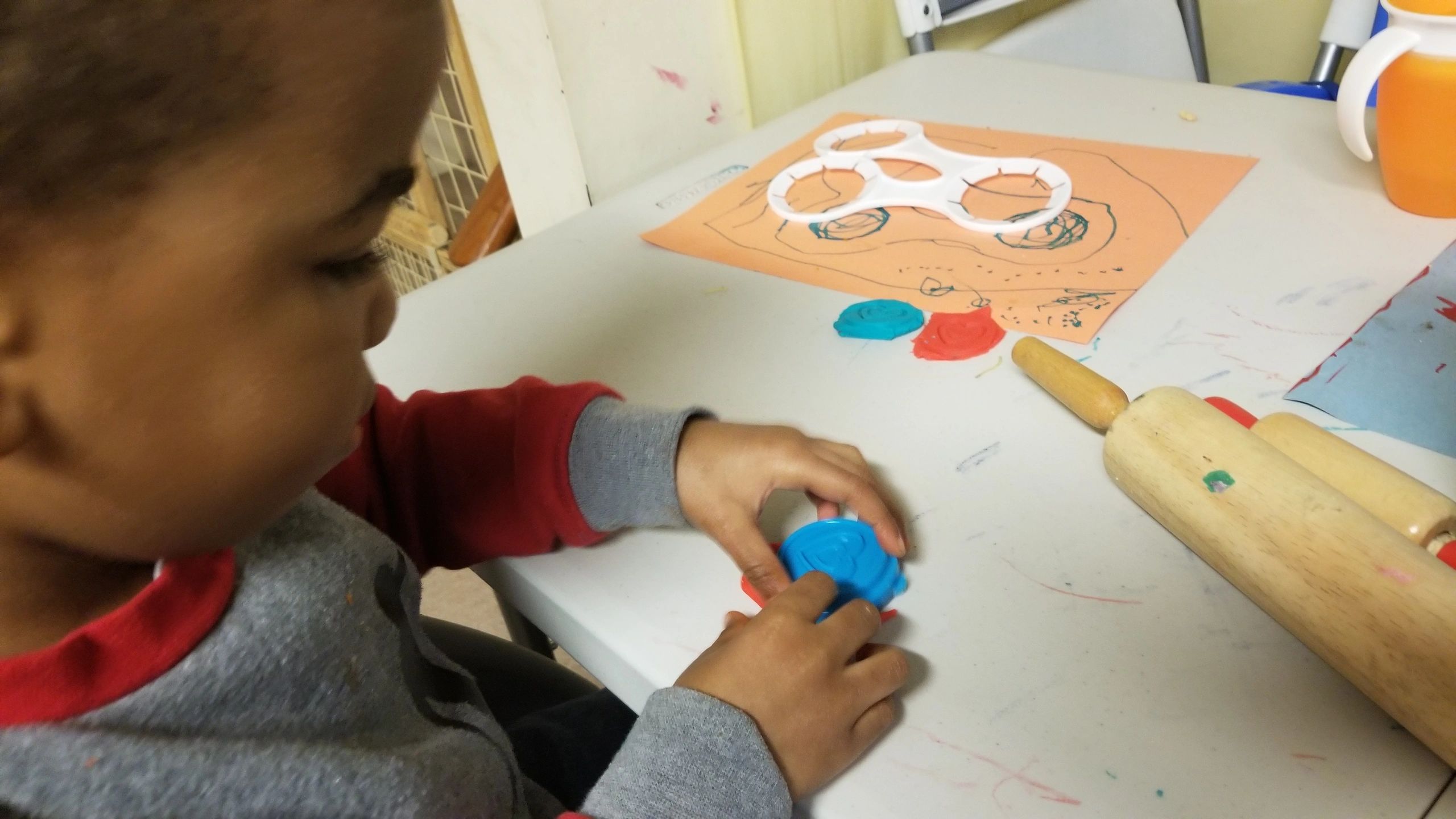 Child playing with blue playdough at Home4Kidz